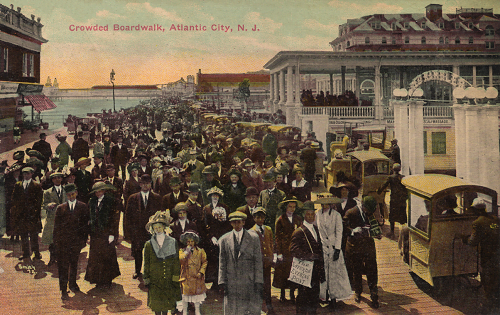 Glossy color postcard of crowded boardwalk in Atlantic City, New Jersey.